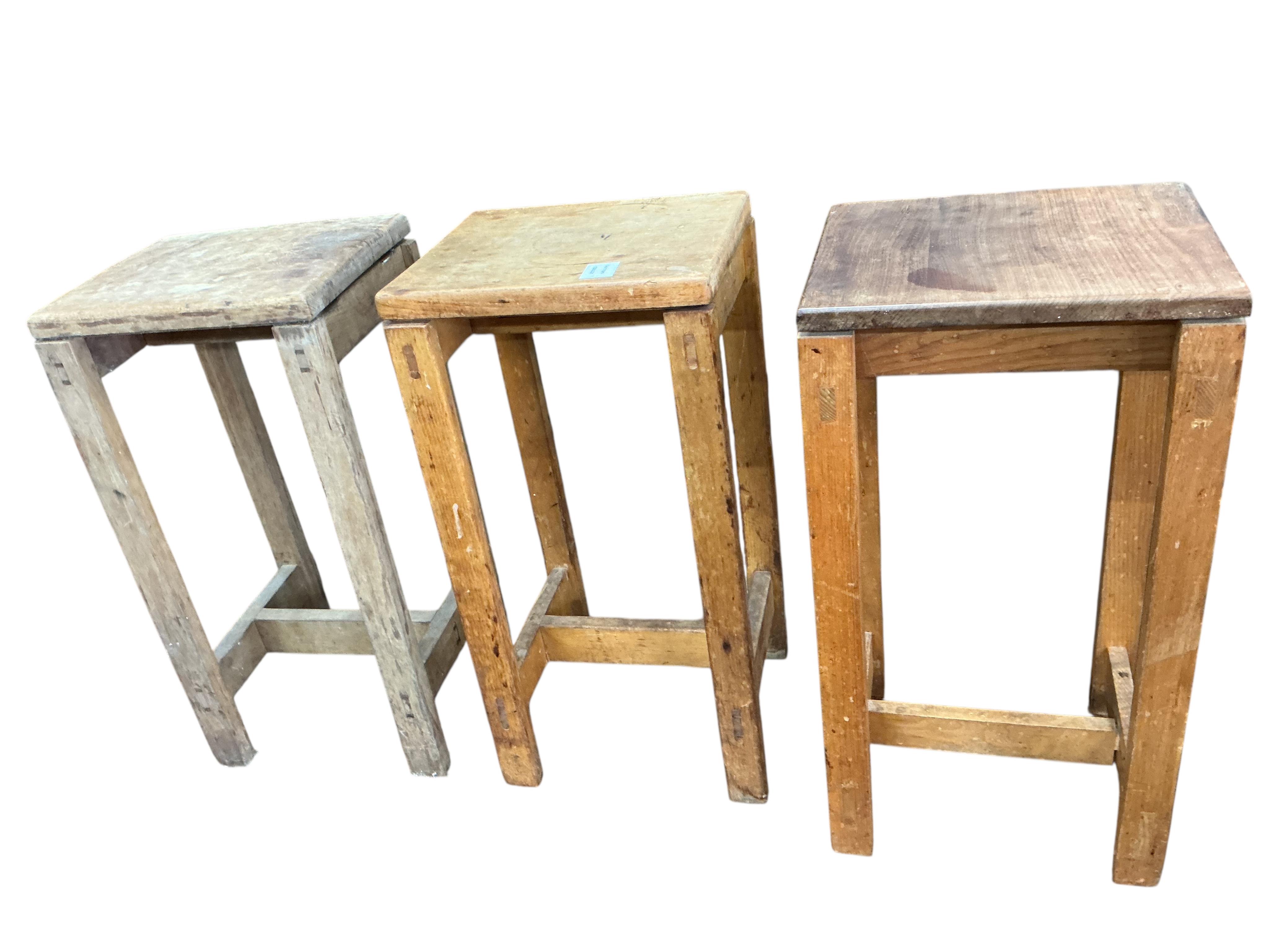 Twelve mid century beech and hardwood laboratory stools, height 65cm